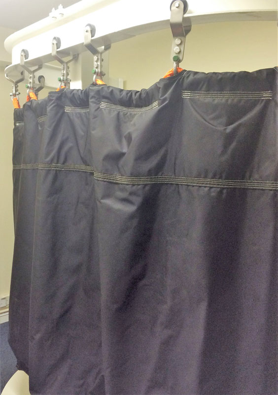 A black shower curtain hanging on the side of a bathroom.